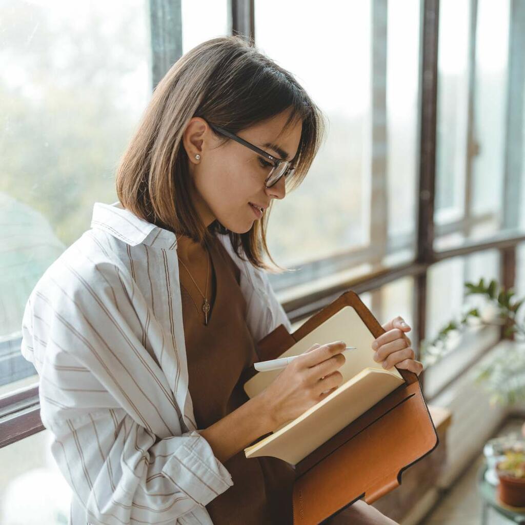 woman smiling and journaling